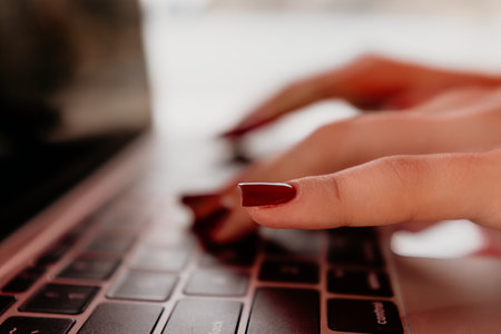 Hands Typing Laptop Keyboard Close-up Image of hands typing on a laptop keyboard. The image is a close-up shot, focusing on the hands and keyboard. The person is likely working or communicating online.の写真素材