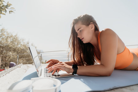 Woman in Orange Swimsuit Working on Laptop Outdoors