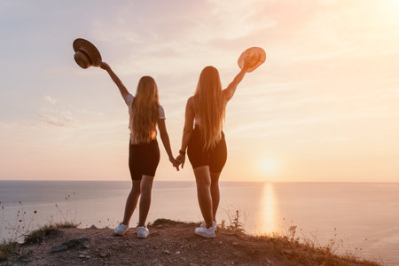 Two Women Holding Hands at Sunsetの写真素材