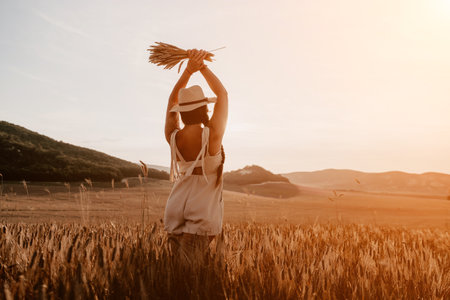 Woman wheat field. Agronomist, Woman farmer check golden ripe barley spikes in cultivated field. Closeup of female hand on plantation in agricultural crop management concept.の写真素材