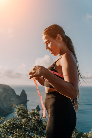 Woman Fitness Mountain Landscape - Young woman in fitness clothing standing on a mountaintop...