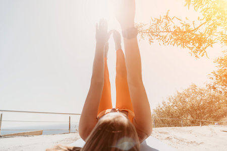 Woman Doing Leg Raises Outdoors in Yoga Poseの写真素材