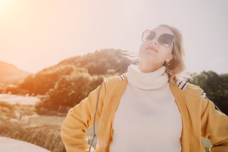 Woman, Sunglasses, Mountain: Female wearing sunglasses, looking at a mountain in a sunny outdoor setting.の写真素材