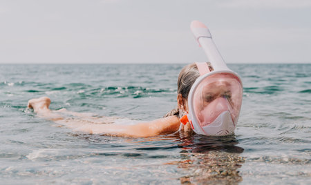 Snorkeling Mask Water Woman - Woman wearing a snorkeling mask floats in the water.の写真素材