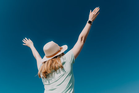 Woman in a Straw Hat Reaching for the Skyの写真素材