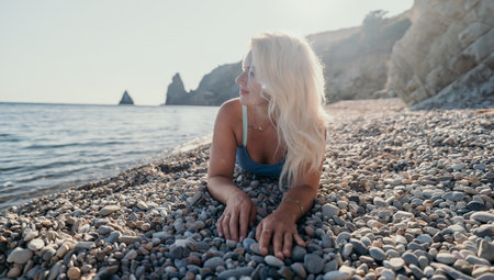 Woman Relaxing on a Pebble Beachの写真素材