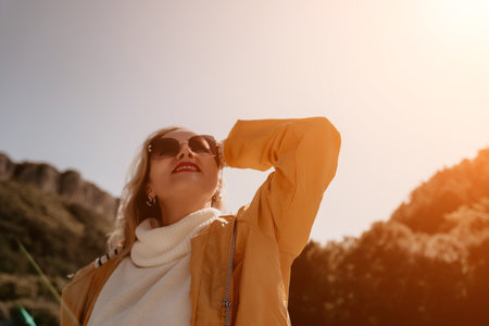 Woman Sunglasses Mountain Hiking - A young woman in sunglasses is hiking in the mountains on a sunny day.の写真素材