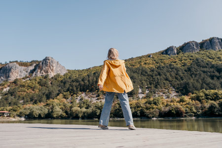Woman in Yellow Jacket on a Wooden Dockの写真素材