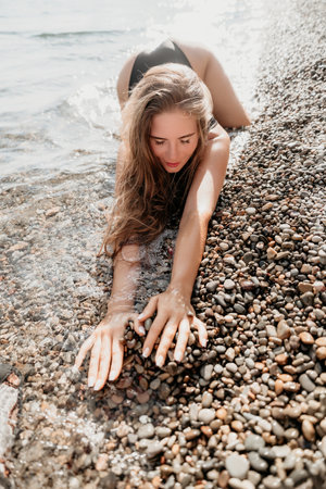 Woman Playing with Pebbles on a Beachの写真素材
