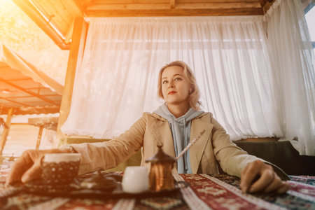 Woman in a Cafe by the Window, Enjoying Coffeeの写真素材