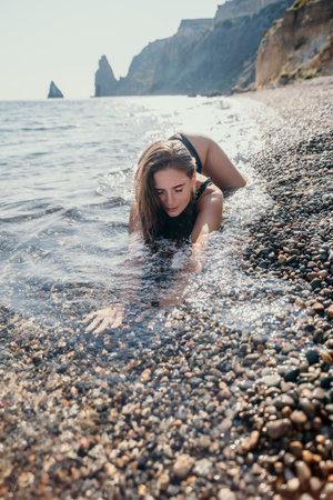 Woman in Black Bathing Suit on a Pebbled Beachの写真素材