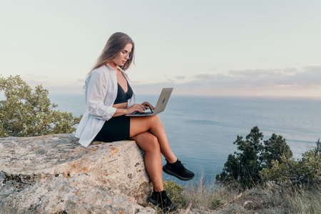 Woman Laptop Mountain - Working remotely on a laptop while enjoying the view from a mountaintop.の写真素材