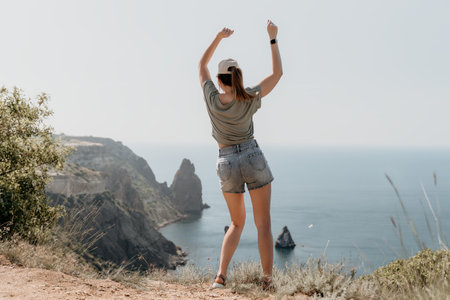 Woman Celebrating on a Mountaintop Overlooking the Sea