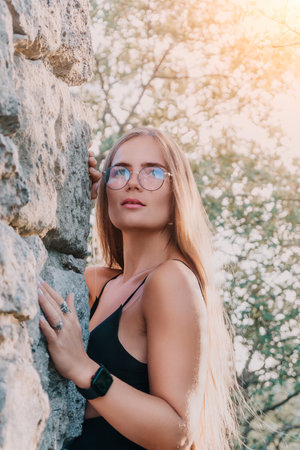 Woman Glasses Stone Wall - Portrait of a young woman wearing glasses standing against a stone wall outdoors.の写真素材