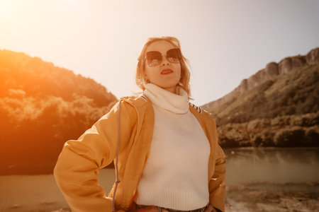 Woman Sunglasses Mountains - A young woman in sunglasses stands in a mountainous landscape.の写真素材