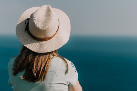 Woman in Straw Hat Gazing at the Oceanの写真素材