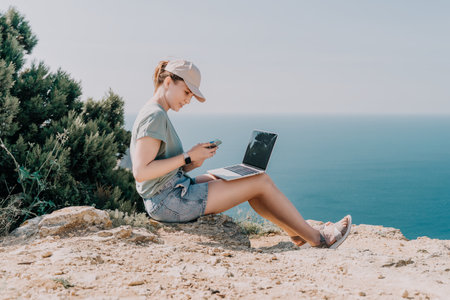 Young Woman Working on a Laptop by the Seaの写真素材