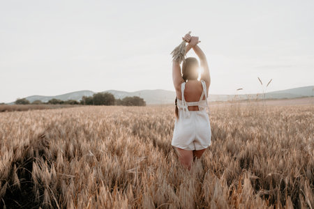 Woman in White Dress Stands in a Field of Wheatの写真素材
