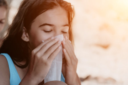 Young Girl Blowing Her Nose with Tissueの写真素材