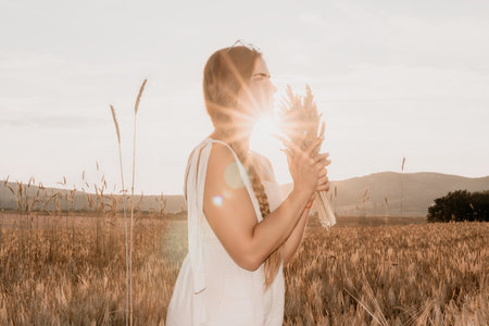 Woman in a Field of Wheat at Sunsetの写真素材