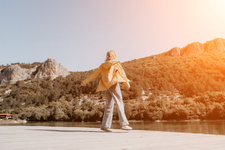 Young Woman Enjoying a Scenic View by the Lakeの写真素材
