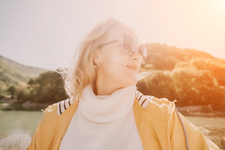 Woman Sunglasses Nature - Blonde woman wearing sunglasses and looking up at the sun in a natural landscape.の写真素材