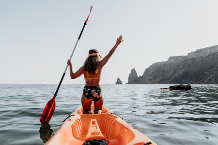 Kayaking, Ocean, Woman: Woman paddles kayak in ocean with mountains in background.
