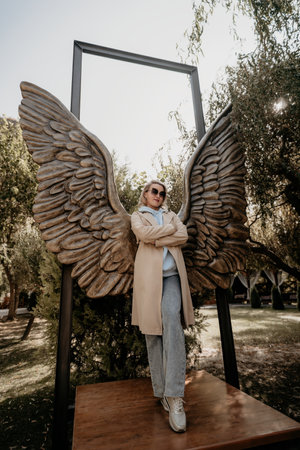 Woman Posing with Angel Wings Sculptureの写真素材