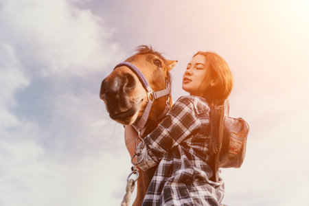 Woman Horse Riding Sky - A woman in a plaid shirt rides a brown horse against a blue sky with white clouds.の写真素材