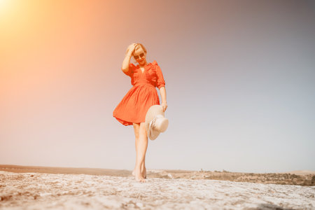 Woman in Red Dress Walking on a Cliffの写真素材