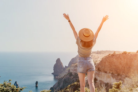 Woman Celebrating on a Mountaintop Overlooking the Oceanの写真素材