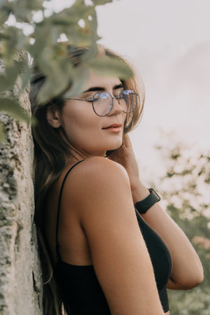 Woman Glasses Tree - Portrait of a woman wearing glasses and standing next to a tree.の写真素材