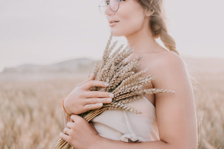 Woman in Wheat Field Holding Sheaf of Grainの写真素材