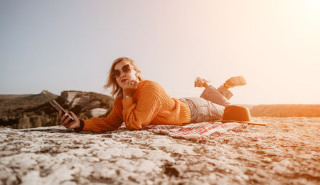 Woman Relaxing on a Mountaintop with a Smartphoneの写真素材