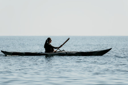 Kayaking Woman Sea Silhouette Sunset: Person paddling kayak in ocean at sunset.の写真素材