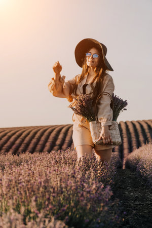 Woman in Hat Walks Through Lavender Fieldの写真素材