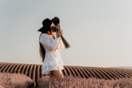 Woman in White Dress Sniffing Lavender in a Fieldの写真素材