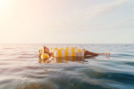 Woman Inflatable Float Relaxing Ocean - A woman relaxes on an inflatable float in the ocean on a sunny day.の写真素材