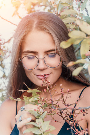 Woman Glasses Flowers - A portrait of a woman wearing glasses and smiling while holding flowers.の写真素材