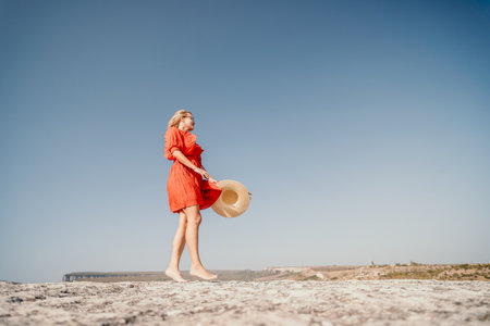 Woman in Red Dress Walking on a Rocky Cliffの写真素材