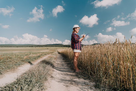 Young Female Farmer Inspecting Wheat Fieldの写真素材