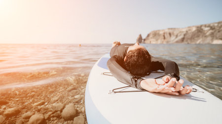 Paddleboard, Ocean, Relaxing - Woman laying on a paddleboard in the ocean, enjoying the sun and a...