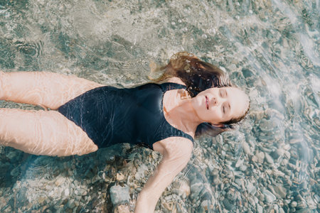 Woman Floating in Clear Waterの写真素材
