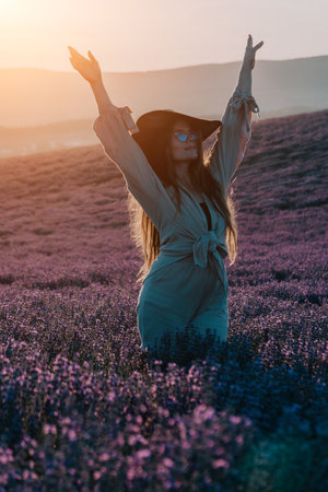 Woman in Hat Enjoying Sunset in Lavender Fieldの写真素材