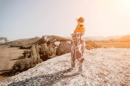 Woman in a Hat and Blanket on a Mountaintopの写真素材