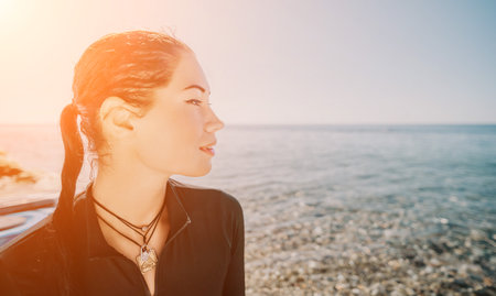 Woman Beach Ocean Sunset: A woman looks out at the ocean on a sunny day.の写真素材