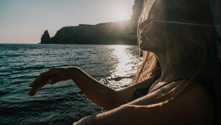 Silhouetted Woman at Sunset by the Seaの写真素材