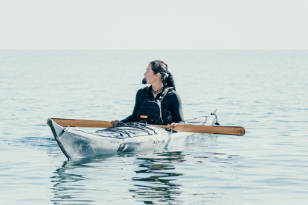 Kayaking Woman Sea Ocean - A woman paddles a kayak on the water, enjoying a day on the sea.の写真素材