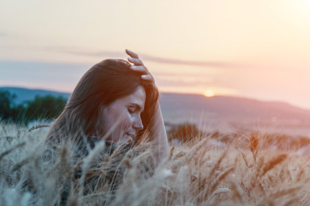 Woman Wheat Field Sunset: Serene evening portrait, peaceful nature scene, contemplative mood.の写真素材