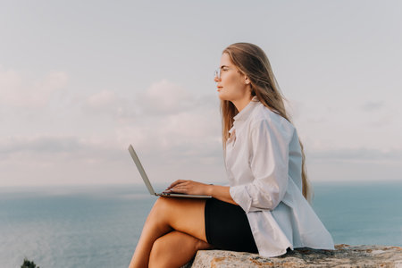 Woman Laptop Beach - Businesswoman working remotely on a laptop with a beautiful ocean view.の写真素材